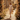 Woman in a floral dress walking through a picturesque street with flower arches.