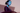 Person wearing a flowing dark purple garment against a neutral background